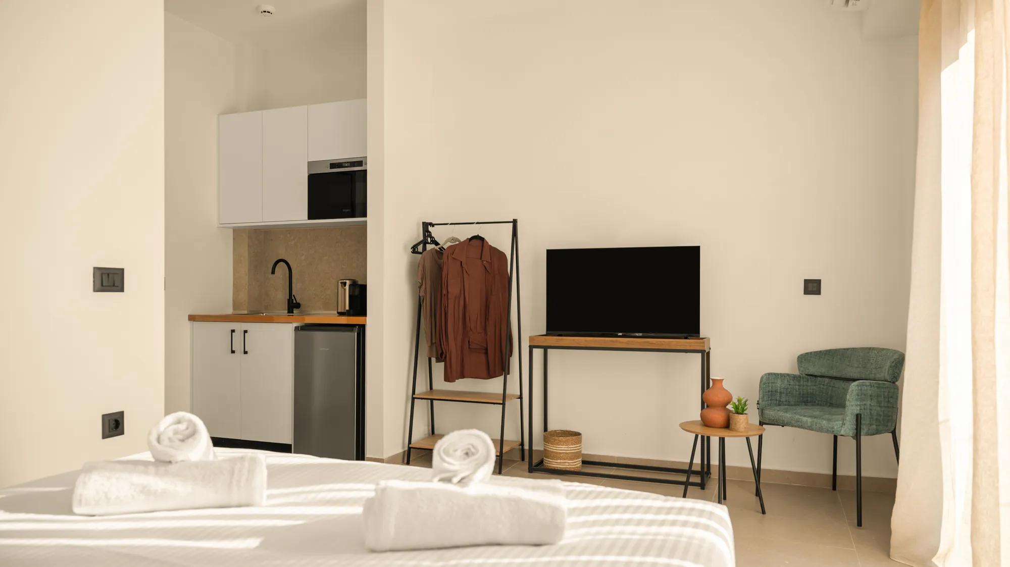 ORMOS Piraeus, the bed, the kitchenette, the clothes rail and the television wall