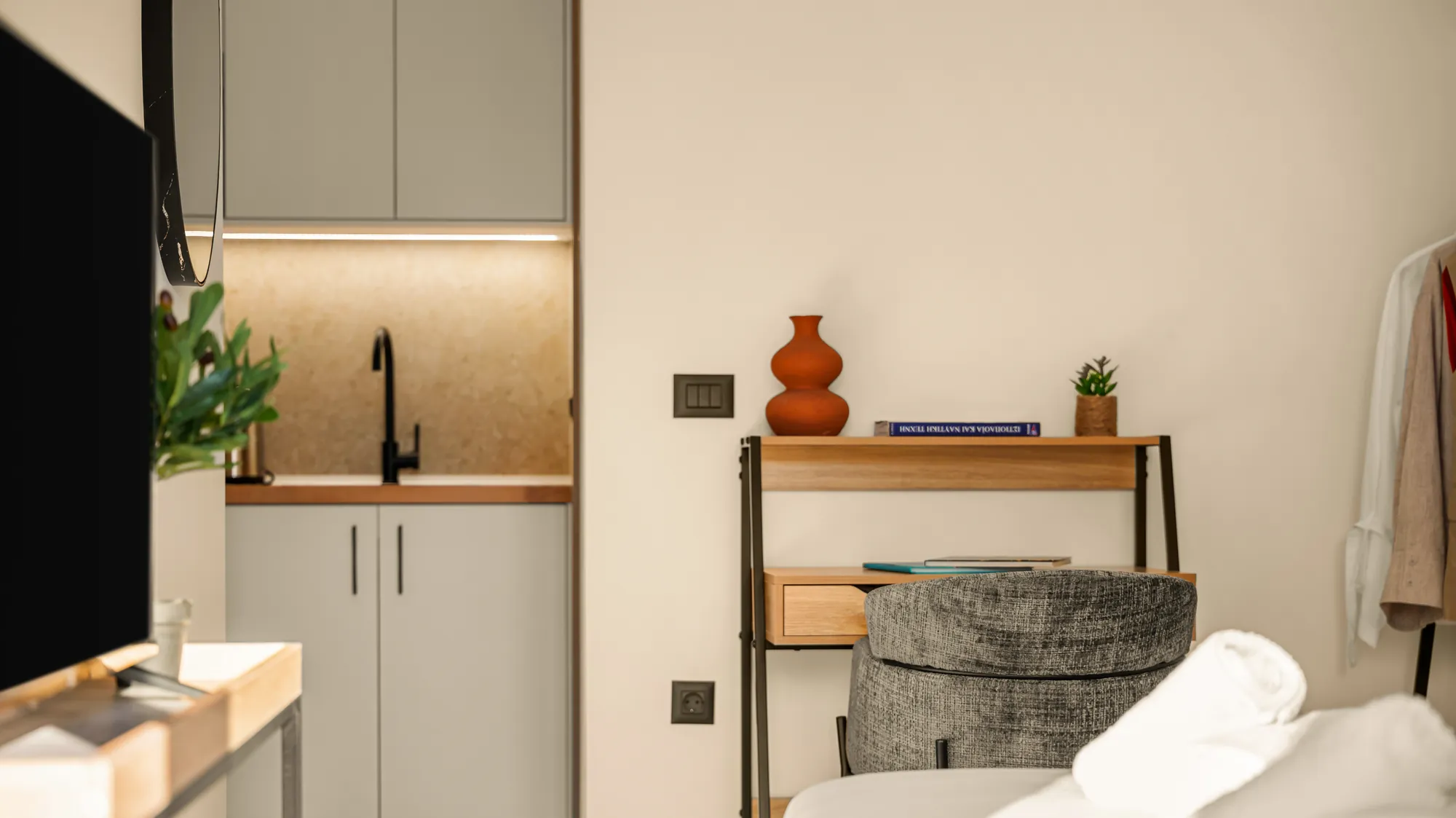 ORMOS Piraeus, the kitchenette, the desk and the armchair beside the bed