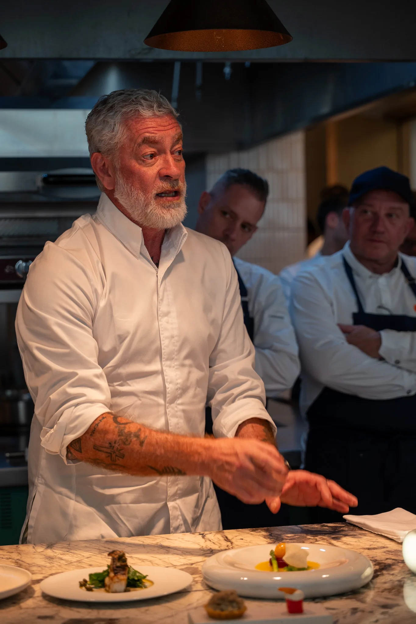 The chef briefing the kitchen team at the pass