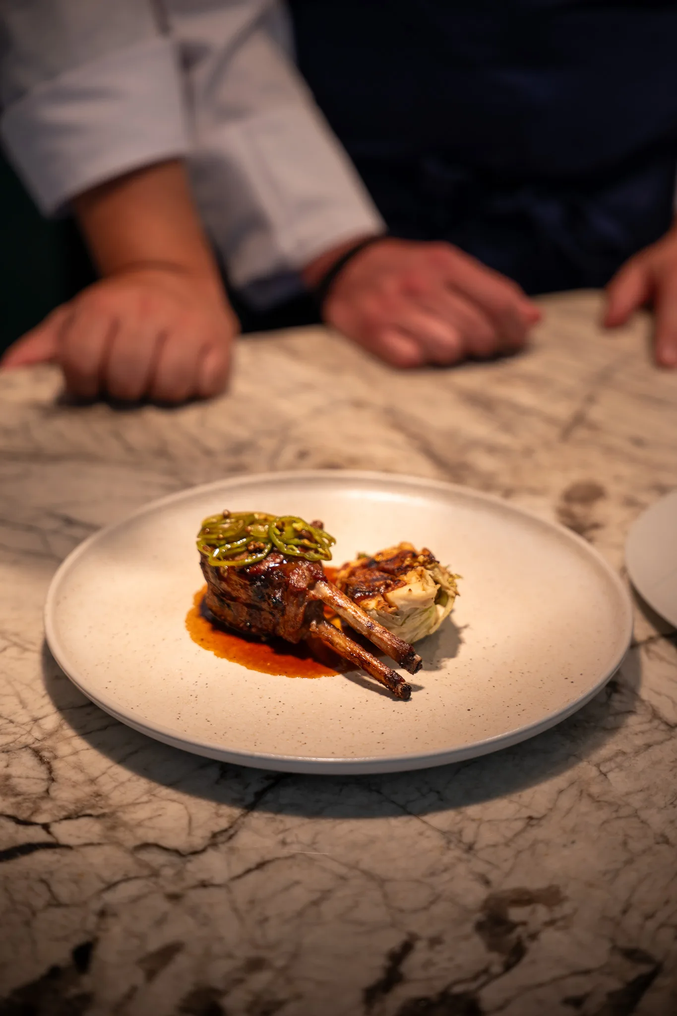 A plated meat course on the marble pass
