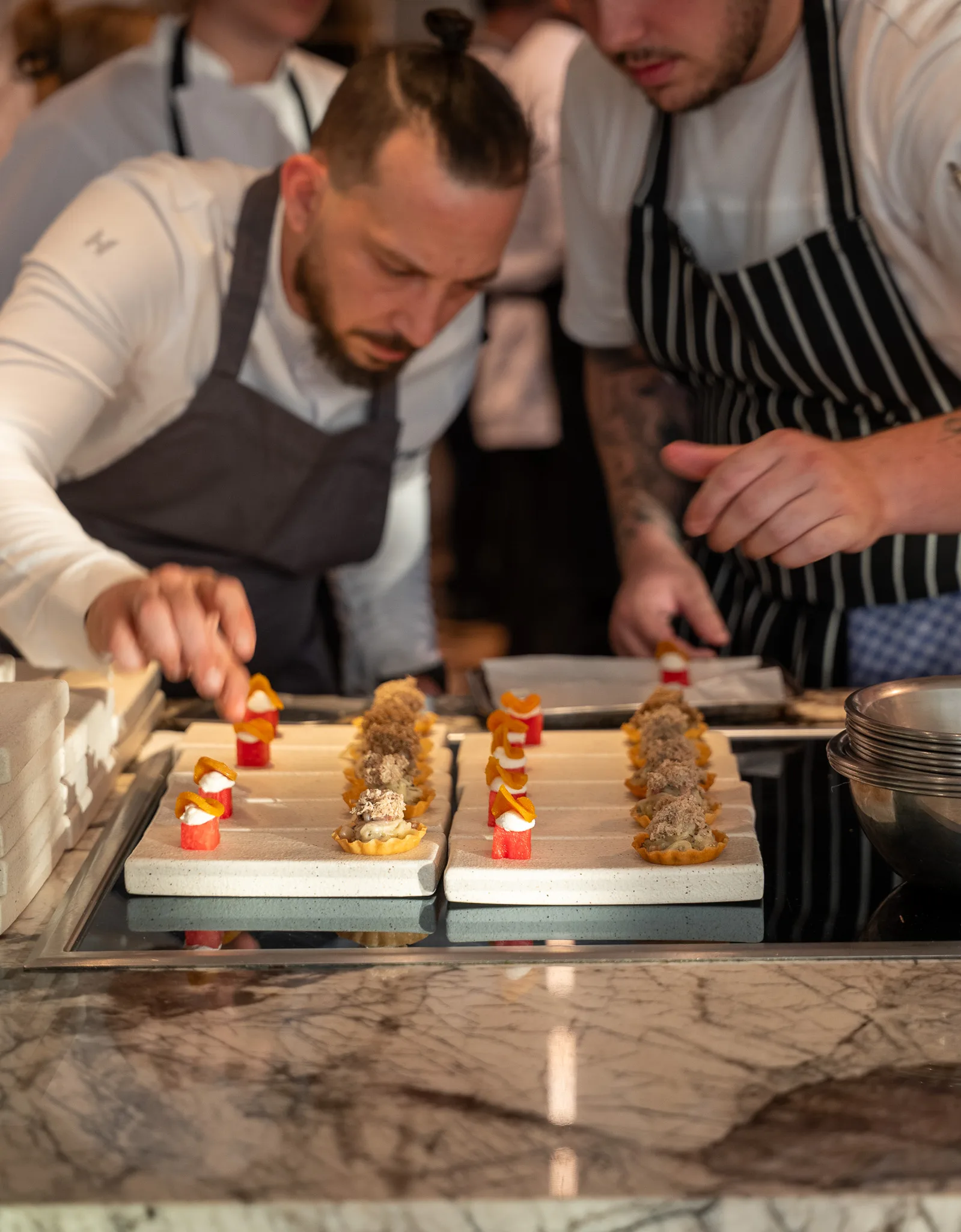 Cooks finishing a tray of small plates