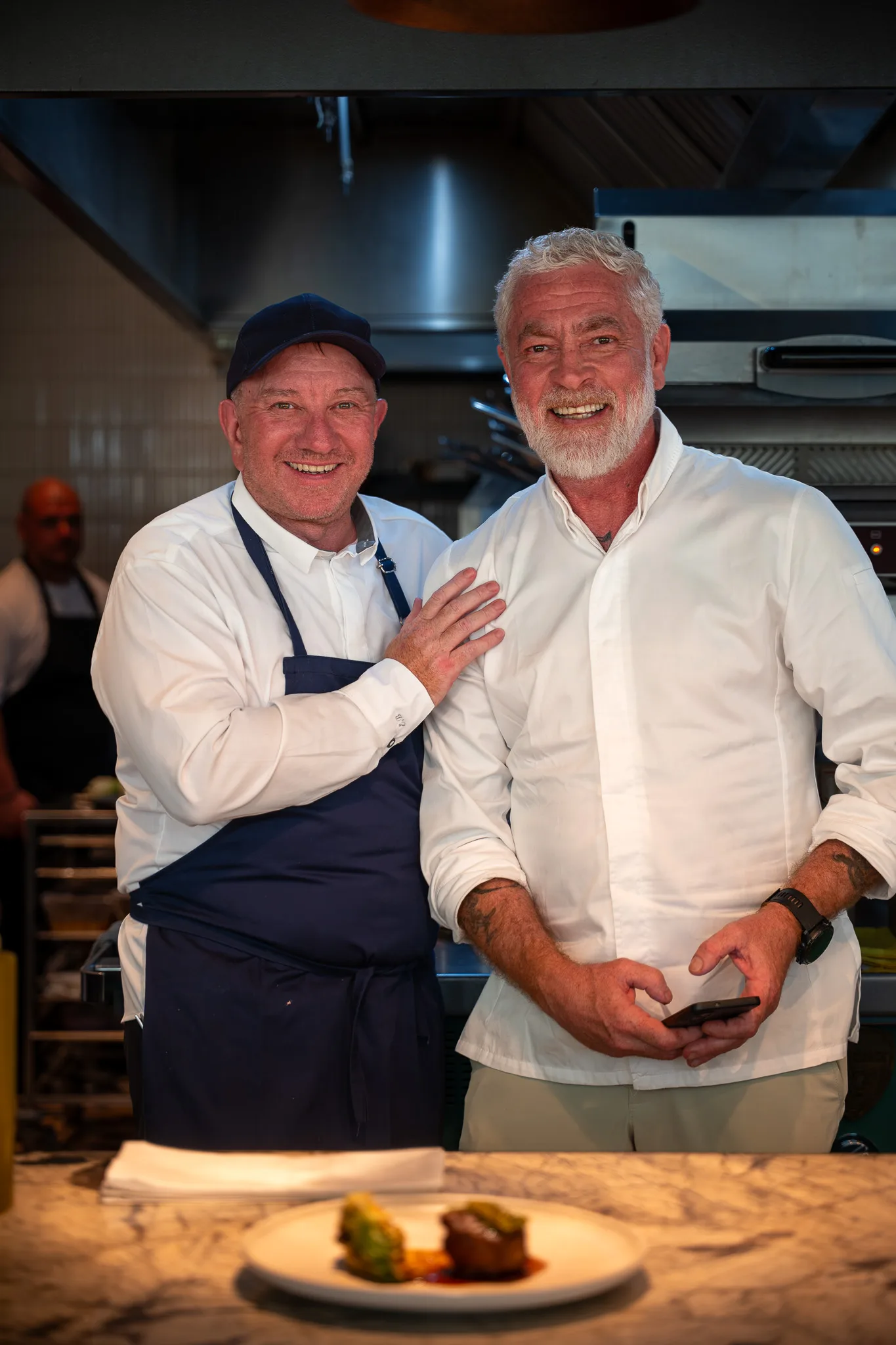 Two chefs photographed together in the kitchen